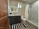 Modern bathroom features a gray vanity and stylish shower with white marble style tiles and shower curtain at 2311 E Colter St, Phoenix, AZ 85016