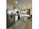 Modern kitchen features stainless steel appliances, white cabinets, an island with seating, and contemporary lighting at 2311 E Colter St, Phoenix, AZ 85016