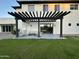 Stylish covered patio with an outdoor seating area, pergola, and view of the grassy backyard at 2311 E Colter St, Phoenix, AZ 85016
