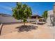 Expansive backyard featuring a covered patio, mature tree, and desert landscaping for outdoor enjoyment at 2701 E Caldwell St, Phoenix, AZ 85042