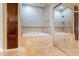 Elegant bathroom featuring a soaking tub with travertine surround and built in cabinets for storage at 2701 E Caldwell St, Phoenix, AZ 85042