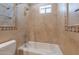Beautiful beige bathroom features tiled tub, with a decorative border and window at 2701 E Caldwell St, Phoenix, AZ 85042