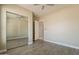 Bedroom with wood-look tile flooring, large mirrored closet, and open door at 2701 E Caldwell St, Phoenix, AZ 85042