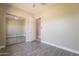 Neutral bedroom with wood-look flooring, closet, and bright window at 2701 E Caldwell St, Phoenix, AZ 85042