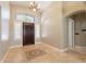 Elegant foyer featuring tile flooring, decorative inlays, chandelier and a view of the arched hallway and windows at 2701 E Caldwell St, Phoenix, AZ 85042