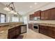 Modern kitchen features stainless steel appliances, dark wood cabinetry, and stone countertops at 2701 E Caldwell St, Phoenix, AZ 85042