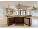 Kitchen island with sink, stone countertop, dark wood cabinets and stainless steel appliances at 2701 E Caldwell St, Phoenix, AZ 85042