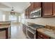Kitchen features stainless steel oven, gas range, granite countertops and dark wood cabinets at 2701 E Caldwell St, Phoenix, AZ 85042