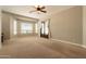 Bright living room with large windows, a ceiling fan, and double front doors with elegant curtains at 2701 E Caldwell St, Phoenix, AZ 85042