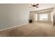 Spacious main bedroom with carpet flooring, a ceiling fan, and a built-in desk area at 2701 E Caldwell St, Phoenix, AZ 85042