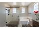 Bright bathroom featuring a glass shower and separate tub with neutral wall colors at 3871 E Harrison St, Gilbert, AZ 85295