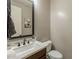 View of the half bath featuring a decorative mirror, vanity and toilet at 3871 E Harrison St, Gilbert, AZ 85295