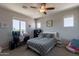 Bedroom featuring a ceiling fan, large window, desk, and light gray decor at 3871 E Harrison St, Gilbert, AZ 85295