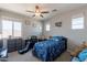 Well-lit bedroom with a ceiling fan, large window, and decorative touches and space theme at 3871 E Harrison St, Gilbert, AZ 85295