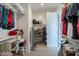 Walk-in closet with white shelves and rods filled with clothing and personal items at 3871 E Harrison St, Gilbert, AZ 85295