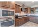 Modern kitchen with built-in microwave and oven, wood cabinets and gray countertops at 3871 E Harrison St, Gilbert, AZ 85295