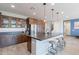 Modern kitchen boasts an oversized island, wood cabinets, stainless steel appliances, and pendant lighting at 3871 E Harrison St, Gilbert, AZ 85295