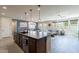 Open concept living room flows into the kitchen featuring a ceiling fan and view into the backyard at 3871 E Harrison St, Gilbert, AZ 85295