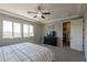 Light-filled main bedroom featuring carpeting, ceiling fan, and TV on a dresser at 3871 E Harrison St, Gilbert, AZ 85295