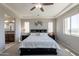 Bright main bedroom with a ceiling fan, en-suite bath, and decorative pillows at 3871 E Harrison St, Gilbert, AZ 85295