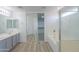 Bright bathroom with double vanity, separate tub, and a glass shower at 43601 W Cowpath Rd, Maricopa, AZ 85138