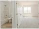View of the tiled shower/bath combo of a bright and airy bathroom, with a large window in adjacent room at 43601 W Cowpath Rd, Maricopa, AZ 85138