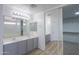Bright bathroom with double vanity and expansive mirrored closet at 43601 W Cowpath Rd, Maricopa, AZ 85138