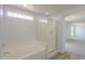 Well-lit bathroom featuring a soaking tub and separate glass shower at 43601 W Cowpath Rd, Maricopa, AZ 85138