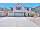 Inviting two-story home featuring a three-car garage, desert landscaping, and a neutral color palette at 43601 W Cowpath Rd, Maricopa, AZ 85138
