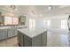 Bright kitchen featuring center island, marble countertops, stainless appliances and tile floor at 43601 W Cowpath Rd, Maricopa, AZ 85138