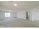 Spacious living room with neutral carpet, bright lighting, and an open layout at 43601 W Cowpath Rd, Maricopa, AZ 85138