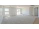 Spacious living room featuring neutral carpet, a sliding door for natural light, and bright, neutral walls at 43601 W Cowpath Rd, Maricopa, AZ 85138