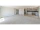 Bright, open living room with neutral carpet flows into a modern kitchen with gray cabinets at 43601 W Cowpath Rd, Maricopa, AZ 85138
