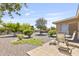 Backyard featuring a patio with outdoor seating and a low-maintenance desert landscape with mature trees at 6631 E Dallas St, Mesa, AZ 85205