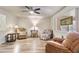 Cozy living room with comfortable seating, wood-look floors, a ceiling fan and a decorative window at 6631 E Dallas St, Mesa, AZ 85205