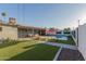 A backyard featuring a pool, artificial grass, a seating area and a brick patio at 8522 E Virginia Ave, Scottsdale, AZ 85257