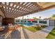 A backyard with a pool, artificial grass, a seating area, and an orange umbrella at 8522 E Virginia Ave, Scottsdale, AZ 85257