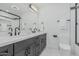 Bathroom with double sinks, modern fixtures, a large mirror, a bathtub-shower combo, and a toilet at 8522 E Virginia Ave, Scottsdale, AZ 85257