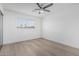 Minimalist bedroom with wood-style floors, a ceiling fan, and a window with wood-style blinds at 8522 E Virginia Ave, Scottsdale, AZ 85257