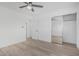 Bedroom featuring wood-style flooring, a ceiling fan, and a closet with mirrored doors at 8522 E Virginia Ave, Scottsdale, AZ 85257