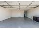 Spacious garage with epoxy flooring, access door, and storage cabinets, perfect for vehicles and projects at 8522 E Virginia Ave, Scottsdale, AZ 85257