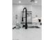 Up-close kitchen sink and refrigerator shot with white cabinetry and marble countertops at 8522 E Virginia Ave, Scottsdale, AZ 85257