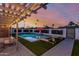Inviting backyard featuring a sparkling pool, waterfall, lounge chairs, and a shaded pergola at 8522 E Virginia Ave, Scottsdale, AZ 85257