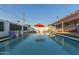 A backyard pool with a waterfall feature and an orange umbrella, surrounded by lounge chairs at 8522 E Virginia Ave, Scottsdale, AZ 85257