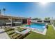Outdoor space with a pool, water feature, lounge chairs, artificial turf, and a covered sitting area at 8522 E Virginia Ave, Scottsdale, AZ 85257