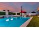 Sparkling pool with sun loungers and a decorative waterfall set against a vibrant twilight sky at 8522 E Virginia Ave, Scottsdale, AZ 85257