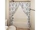Bathtub/shower combo with a decorative elephant curtain and a shower head at 10065 E Tiger Lily Ave, Mesa, AZ 85212
