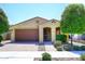 Charming single-story home with a well-maintained front yard, a desert landscape, and a two car garage at 10065 E Tiger Lily Ave, Mesa, AZ 85212