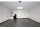 Spacious garage with epoxy floors, white walls, water heater, and utility sink at 10065 E Tiger Lily Ave, Mesa, AZ 85212