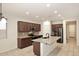 Spacious kitchen with dark wood cabinets, granite countertops, stainless steel appliances, and a large island at 10065 E Tiger Lily Ave, Mesa, AZ 85212